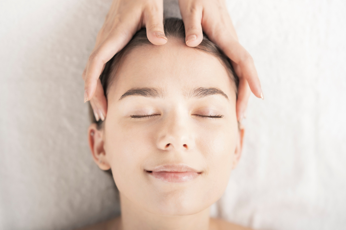 Young woman having her head massaged